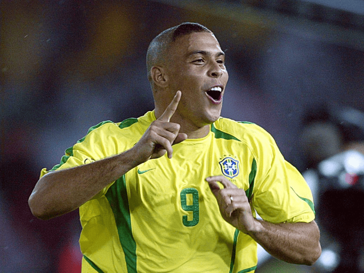 Brazilian soccer player in a yellow jersey with number 9 celebrating a goal, raising a finger in the air
