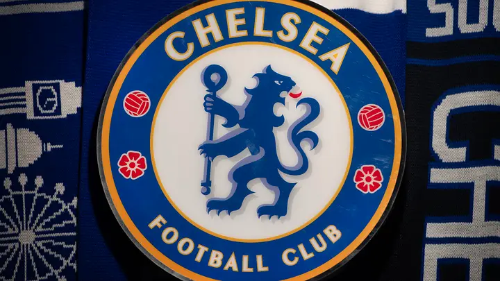 Chelsea Football Club crest: blue circle with a gold border, a blue lion holding a staff, surrounded by red roses and text.