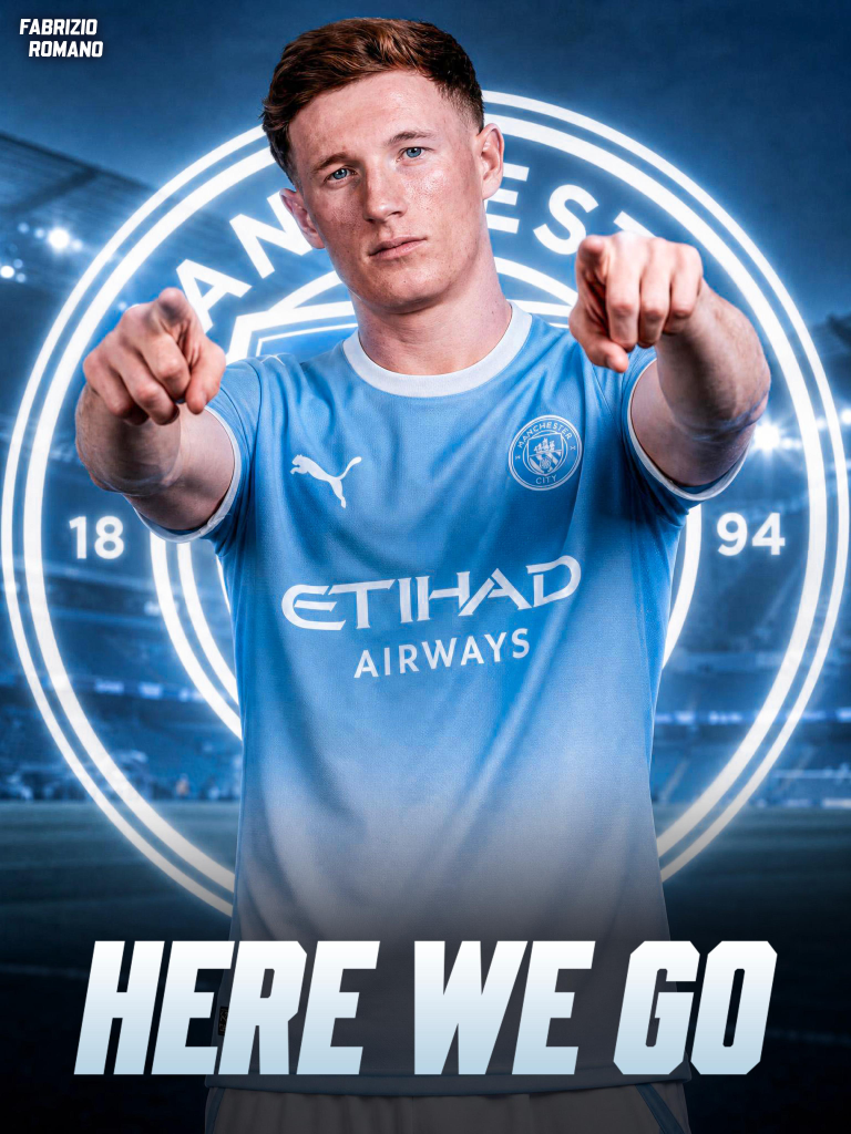Footballer in Manchester City kit points at the camera with a glowing club emblem behind him and 'HERE WE GO' text at the bottom.