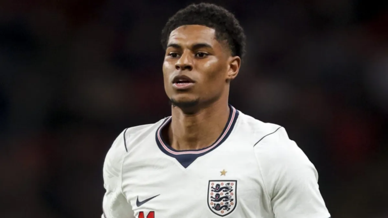 Male soccer player in an England white jersey on the field, facing forward with focused expression.