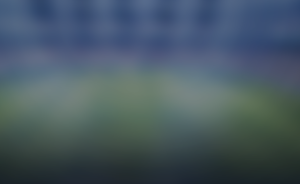 Blurred gradient background resembling a hazy landscape with blue sky at top and green fields at bottom (out of focus).