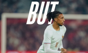 Footballer in a light kit running on a soccer field, with the large word 'BUT' overlaid at the top.