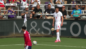 Soccer scene at a corner with England in white #4 and a red opponent near the ball as fans watch from the stands.