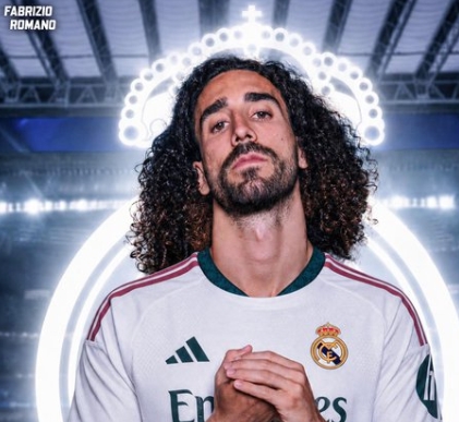 Portrait of a man with long curly hair wearing a Real Madrid jersey, standing in front of a bright circular neon backdrop with a halo-like ring behind him.