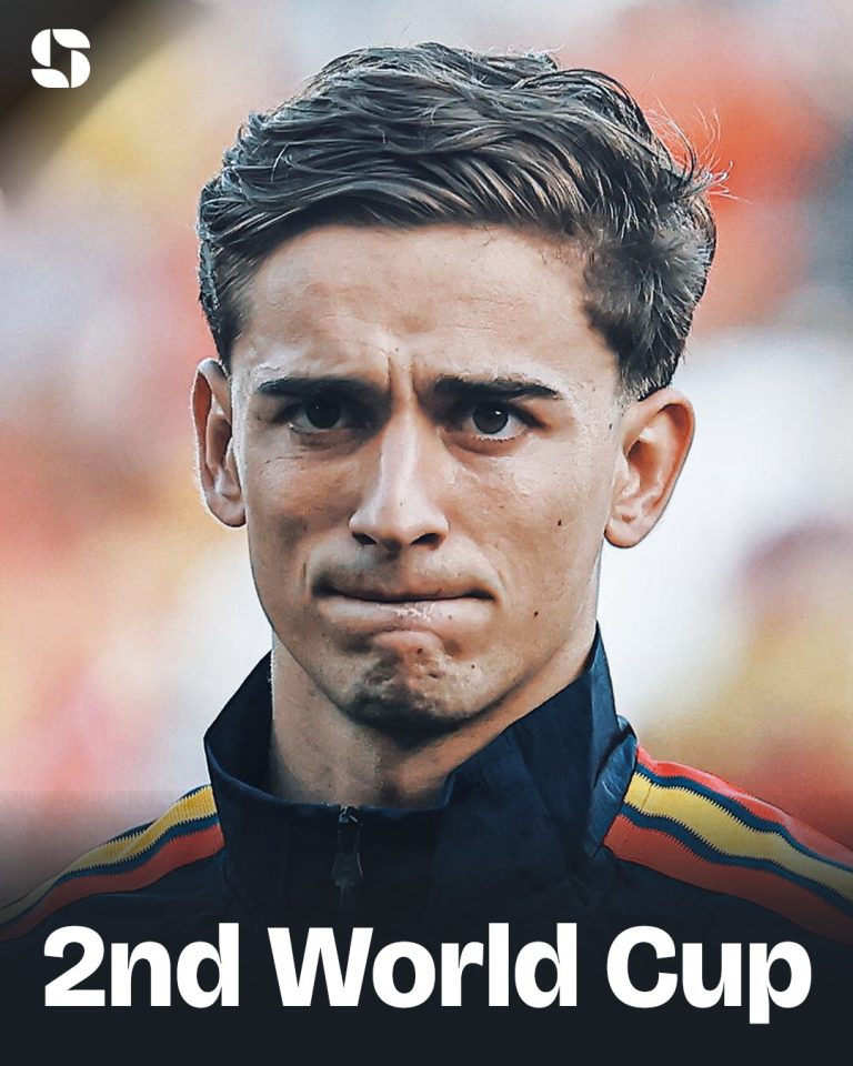Close-up of a young male athlete with a determined expression, wearing a dark jacket with red, yellow, and blue stripes; '2nd World Cup' text at the bottom.