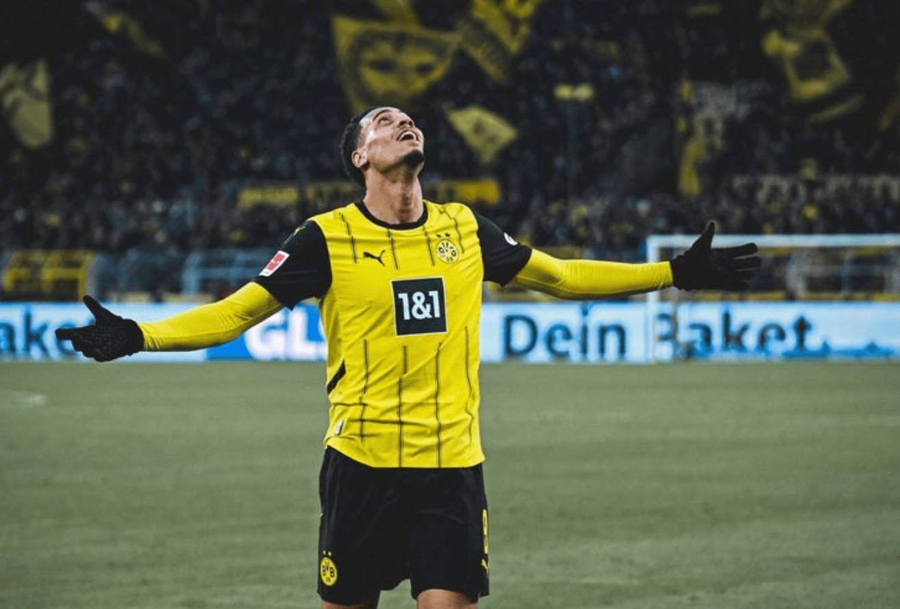 hupu-football-1781551536628-ayx-1png - AYX Sports Hub Soccer player in a yellow and black Dortmund jersey celebrating with arms outstretched on the field.