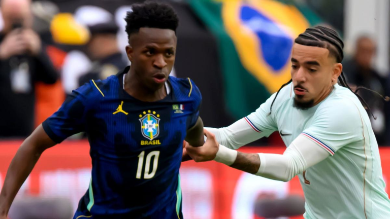 Soccer action: Brazilian player wearing blue jersey number 10 being challenged by a defender in white.