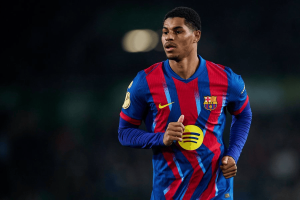 Soccer player in FC Barcelona blue-and-red striped jersey running on a dim field at night.