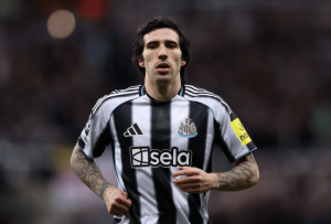 Footballer wearing a Newcastle United striped jersey running on the pitch during a match
