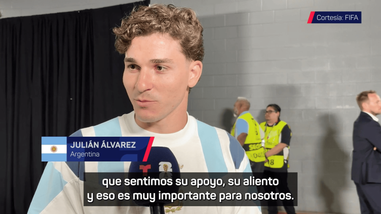 Argentine soccer player giving a post‑game interview, with Argentina flag graphic and FIFA courtesy badge in the background.