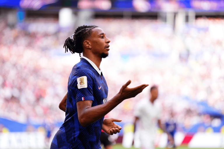 Soccer player in a blue jersey running on a crowded stadium field.