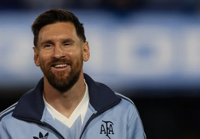 Smiling man with a beard in a light blue jacket with an AFA emblem, facing the camera.