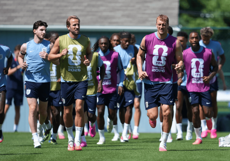 Group of soccer players running on a training field in colorful bibs marked FIFA World Cup 2026.
