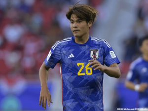 Japanese national team soccer player wearing jersey number 26, mid-action on the field during a match