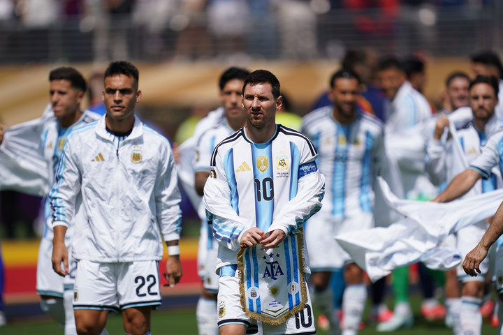 Argentine national soccer team players walking onto the field before a match; foreground player wears number 10 in blue-and-white jersey.