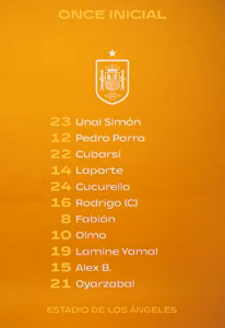 Starting XI lineup graphic on an orange background with a team crest and a bottom caption reading 'ESTADIO DE LOS ÁNGELES' - lists players by number and name (e.g., Unai Simón, Porro, Laporte).