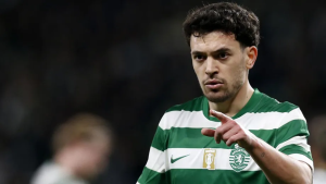 Male soccer player in a green-and-white striped Sporting CP jersey points forward during a match.